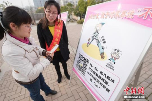 資料圖：今年3月8日，安徽合肥新華社區(qū)志愿者夏一瓊(右)向市民普及反家暴相關(guān)法律知識(shí)。鐘欣 攝