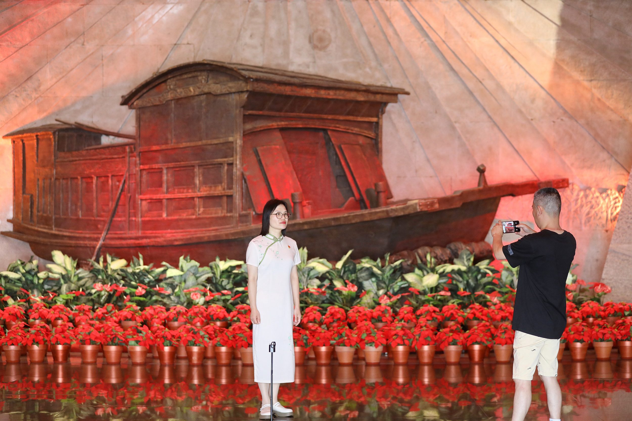 2025年6月24日，浙江嘉興，游客在南湖革命紀念館與紅船雕塑合影。（圖片來源：視覺中國）